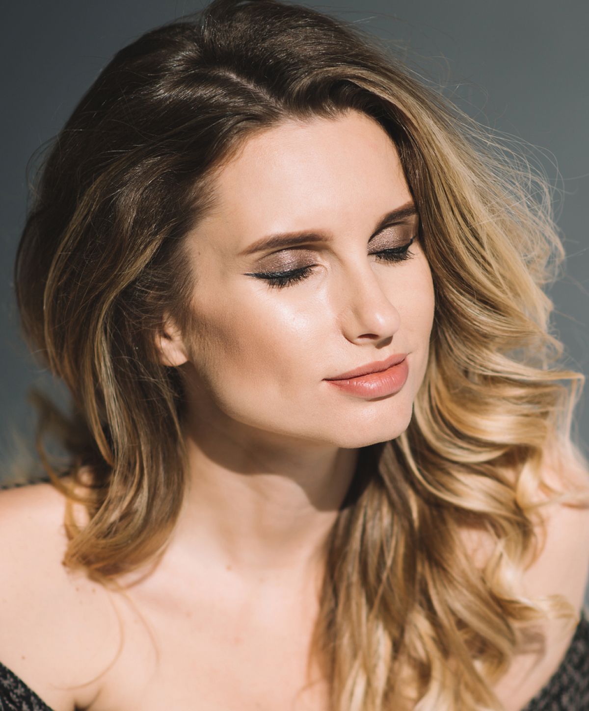 Smiling woman with hands under chin backdrop.