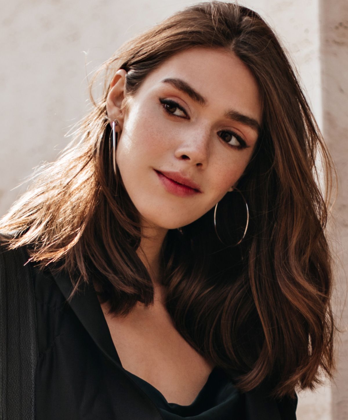 Woman with long hair and hoop earrings.