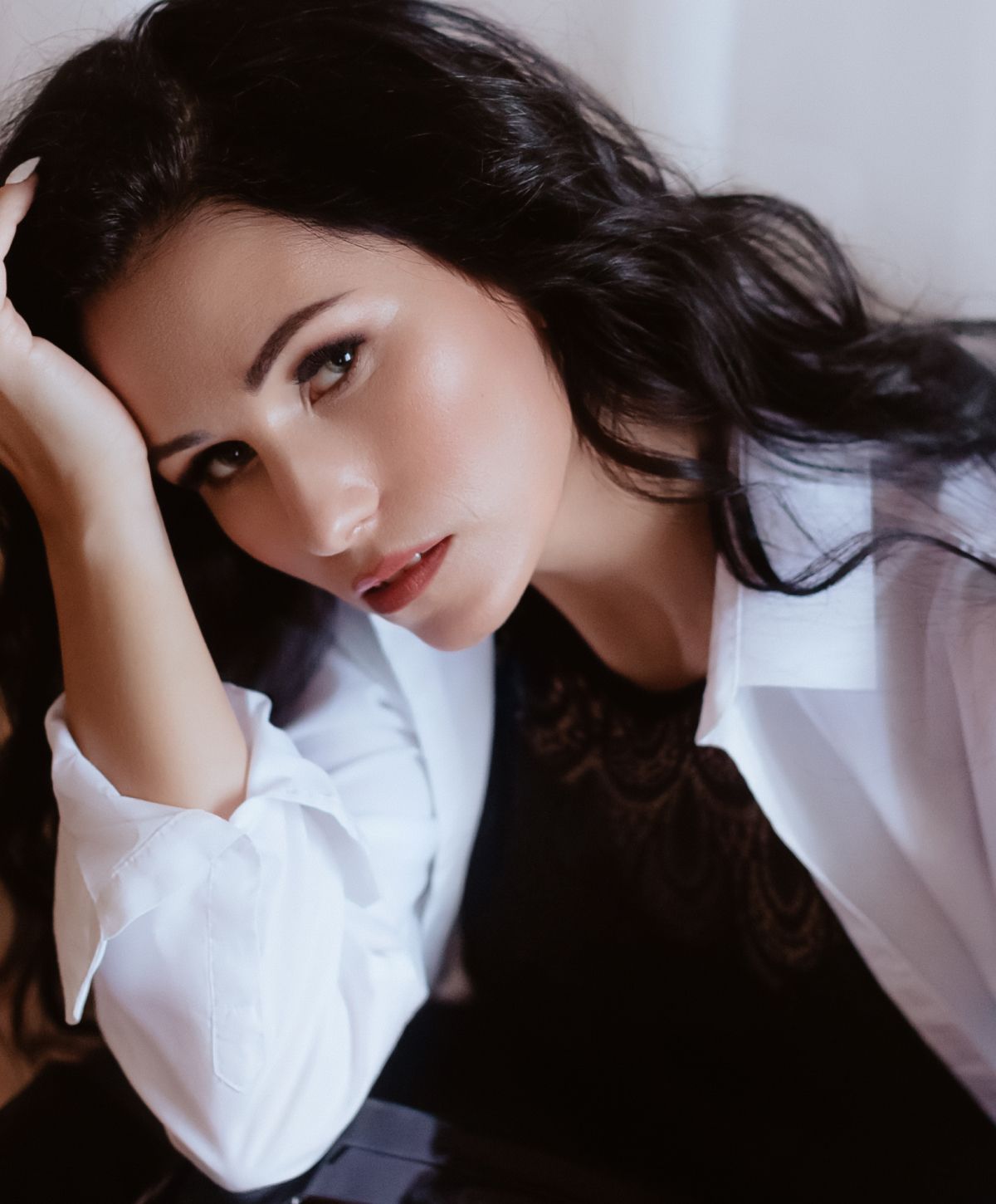 Woman in white shirt resting her head.