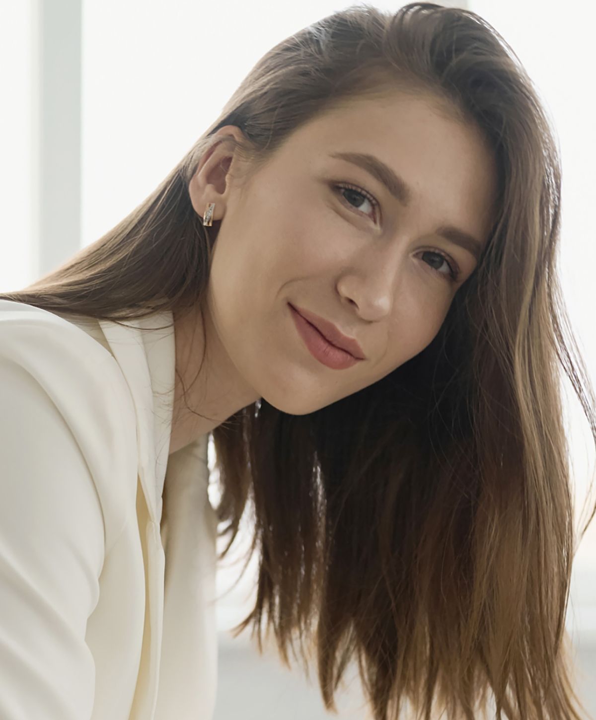 Smiling woman with long hair in professional attire.