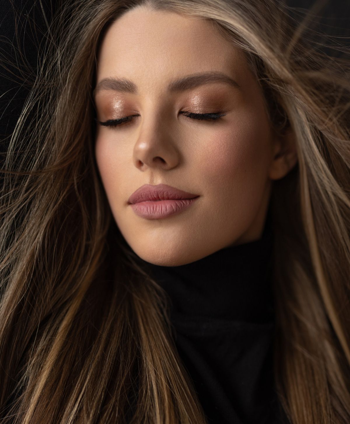 Portrait of woman with closed eyes and flowing hair.