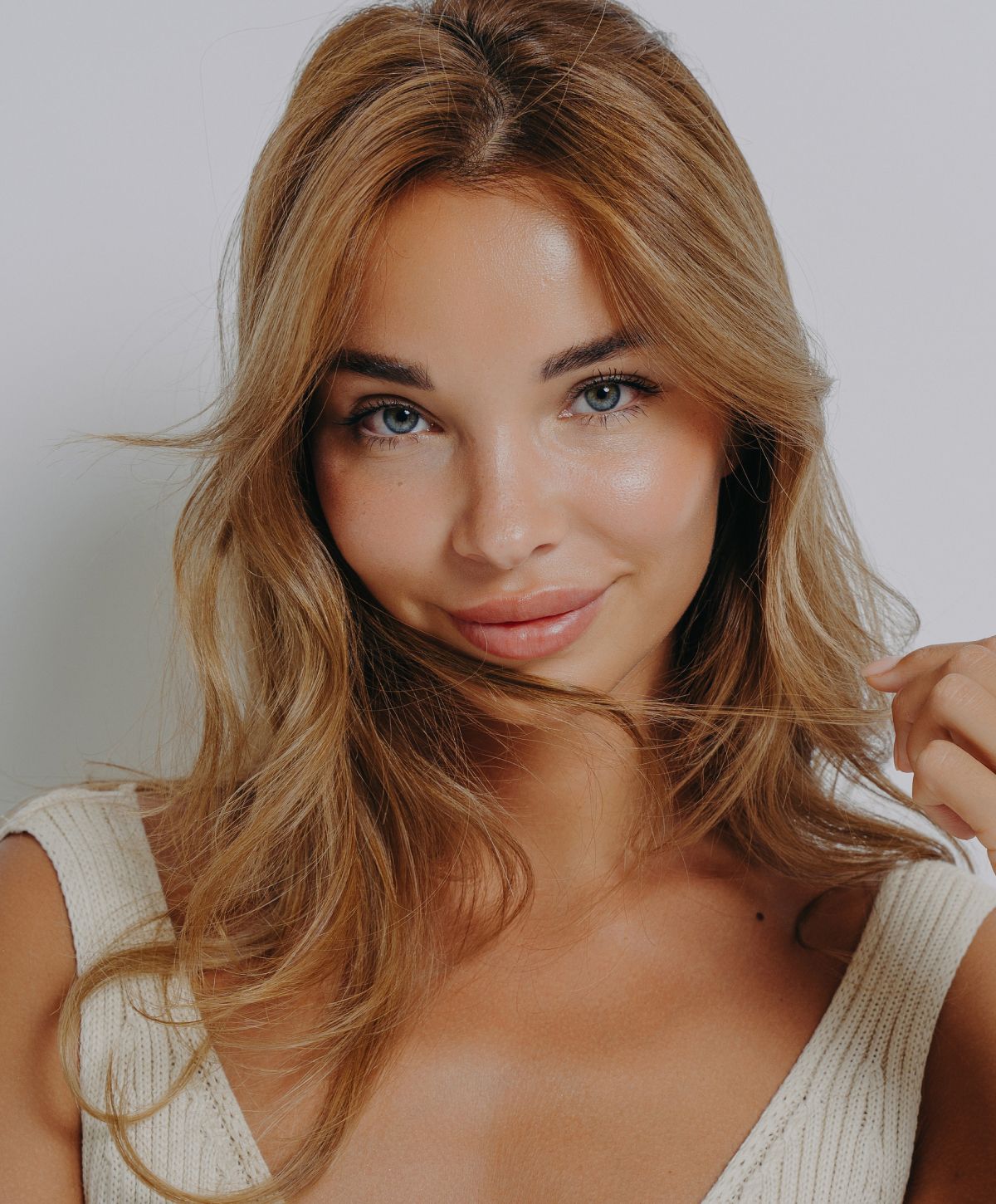 Smiling woman with long, wavy blonde hair.