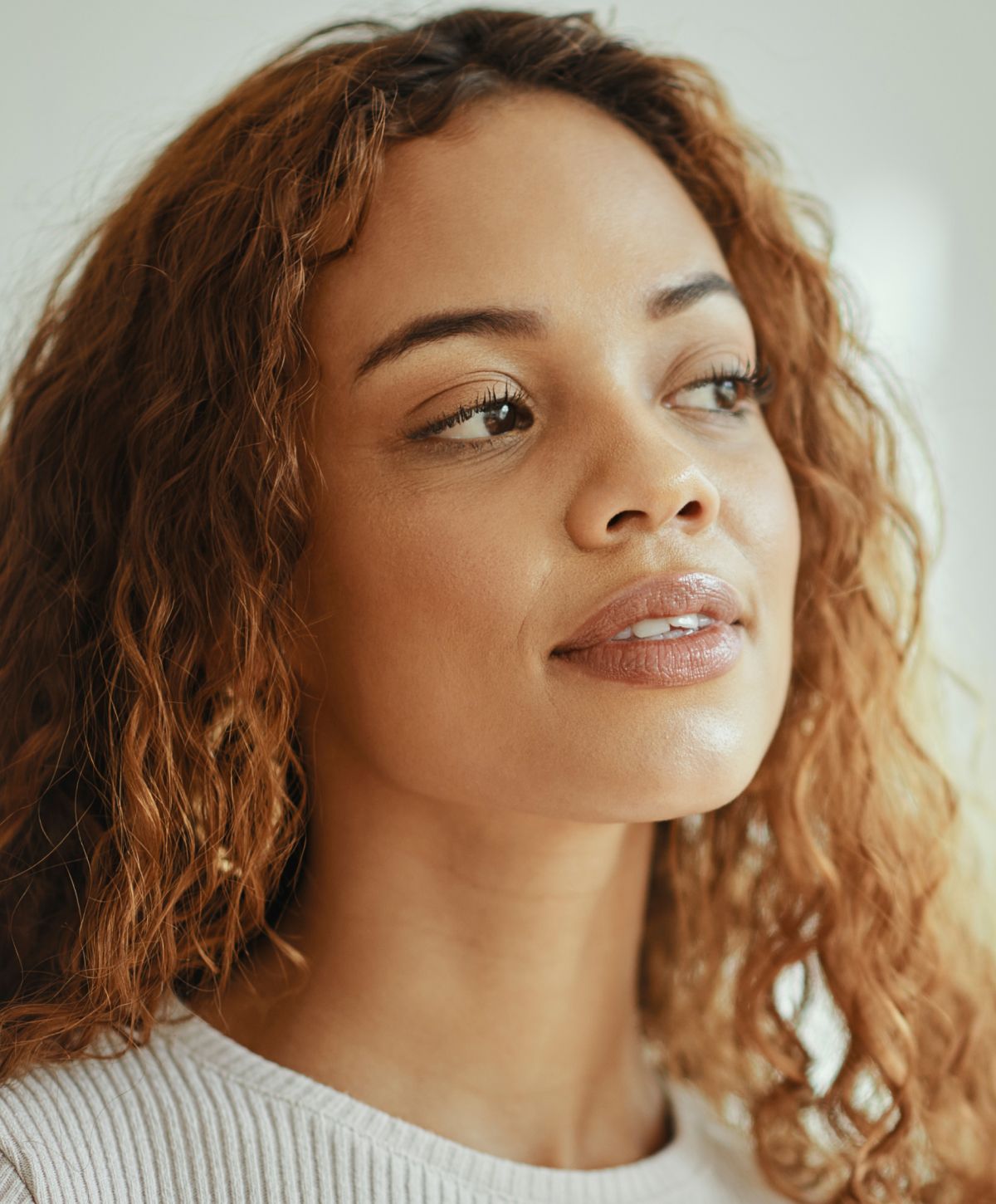 Close-up of young woman with curly hair.