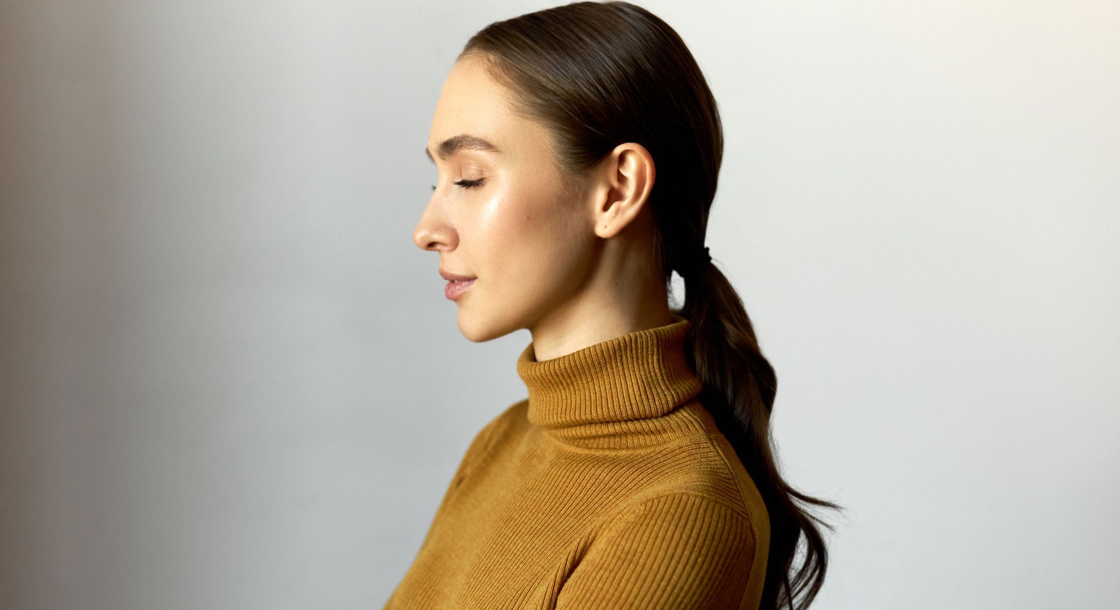 Profile view of a woman in a turtleneck.