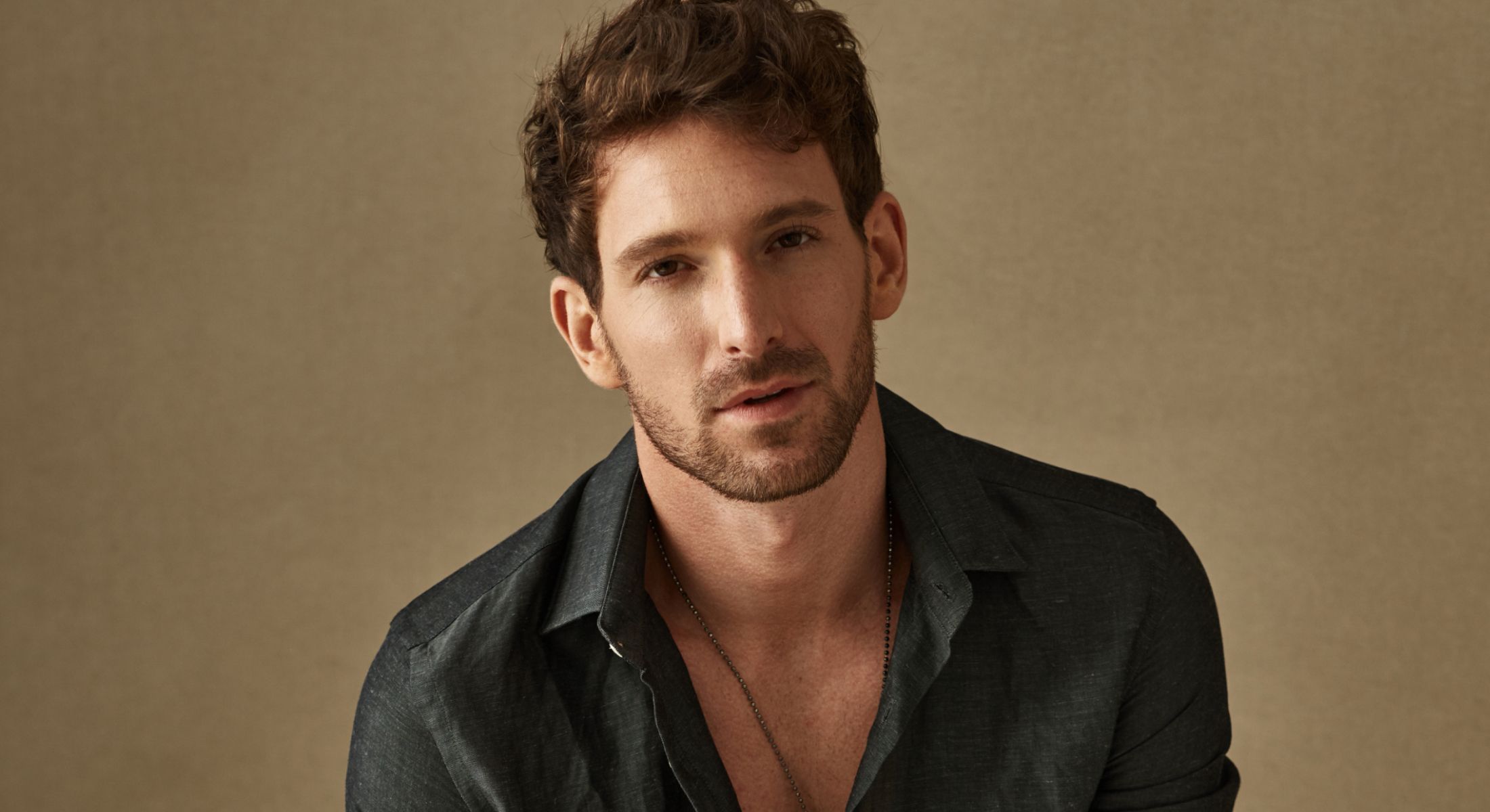 Man in a casual shirt against a neutral background.