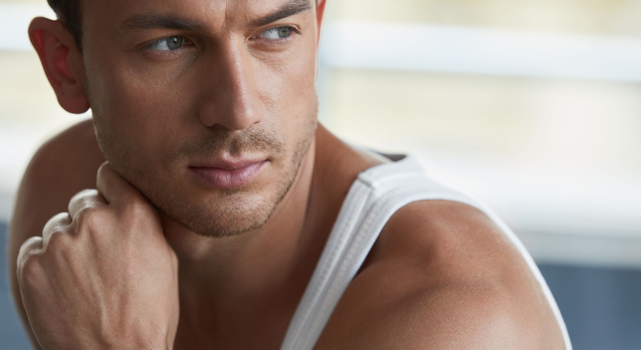 Close-up of thoughtful man in tank top.