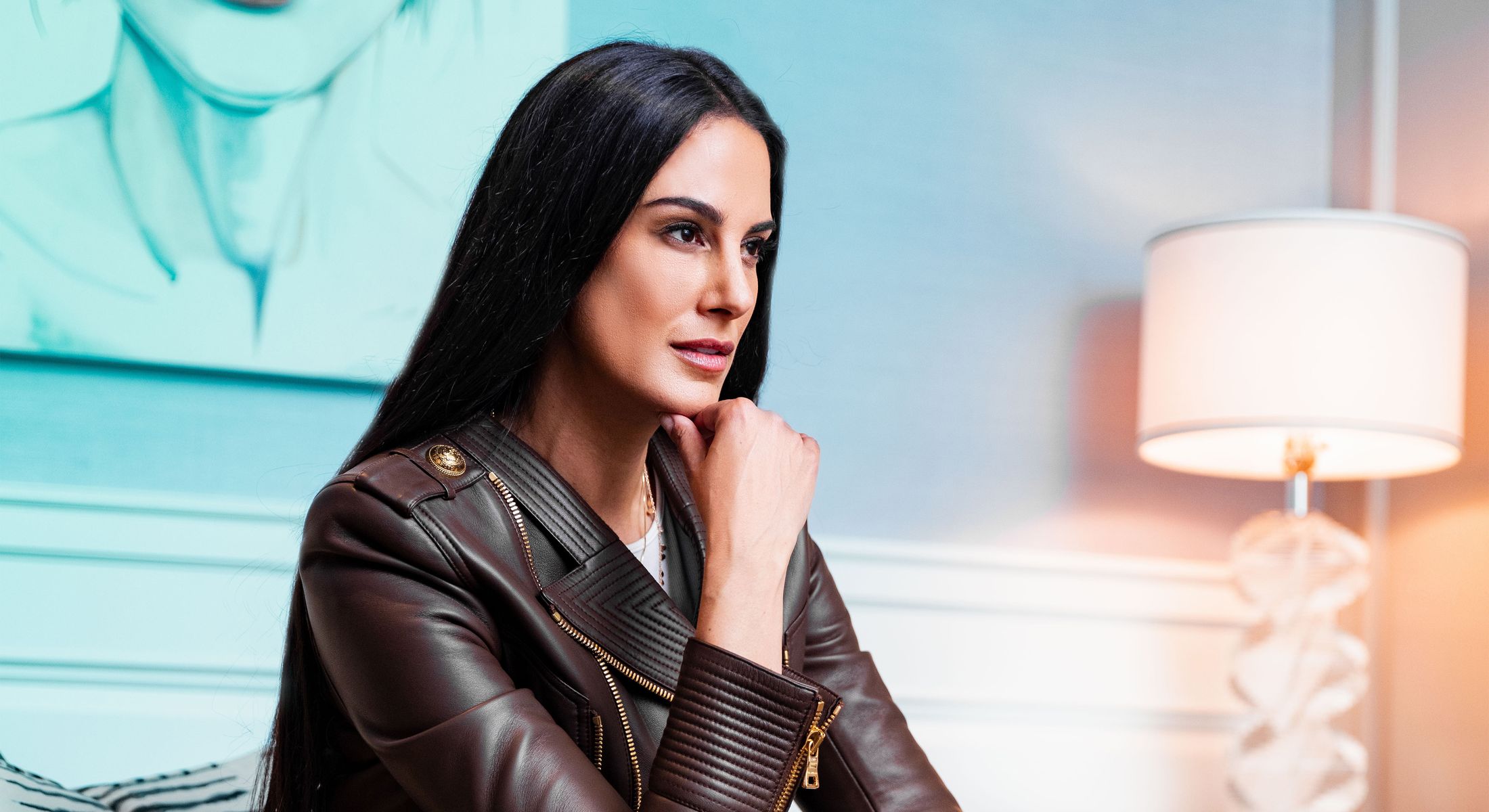 Person thoughtfully pondering in a stylish setting.