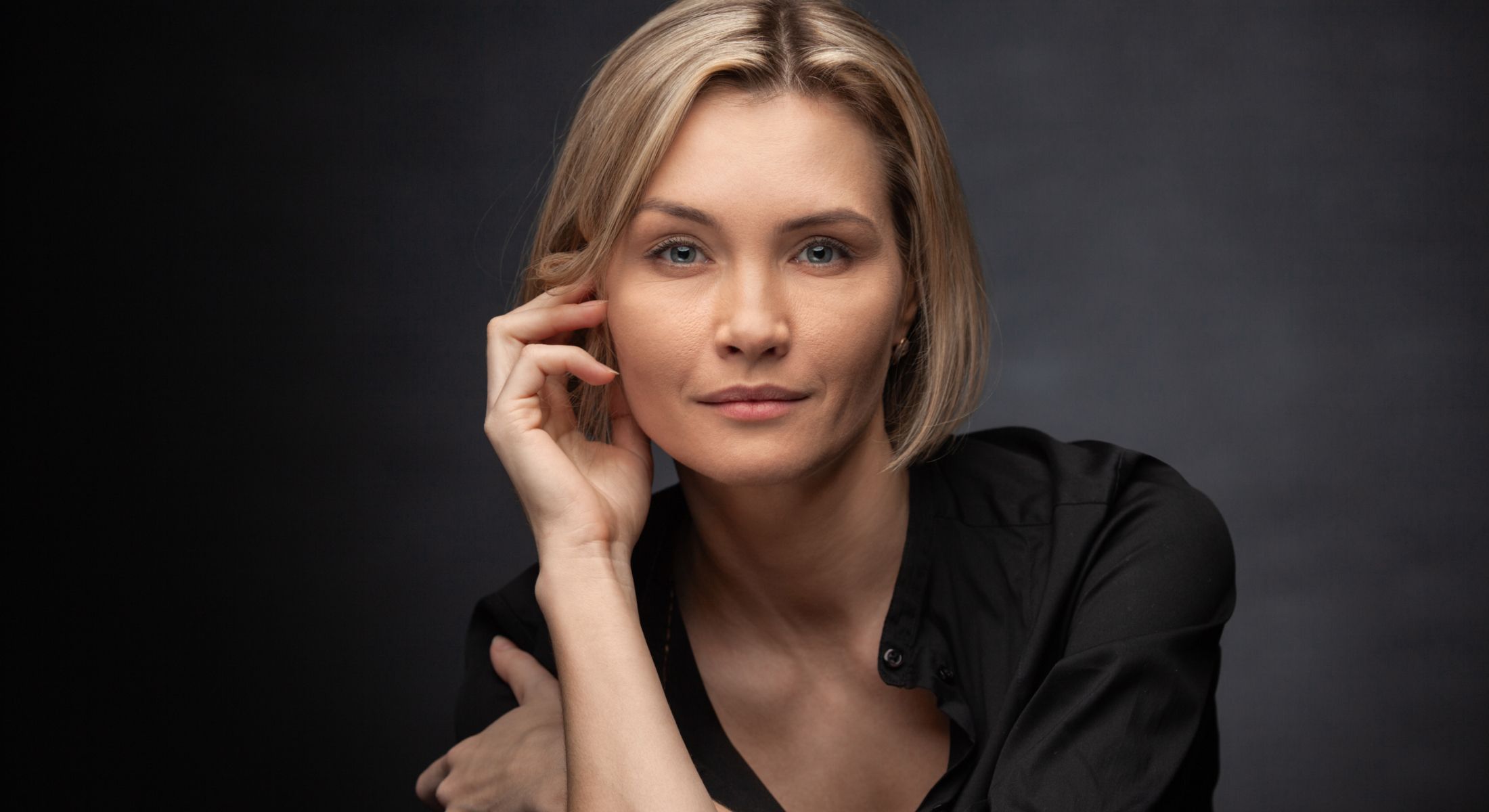 Woman with short blonde hair in black shirt.