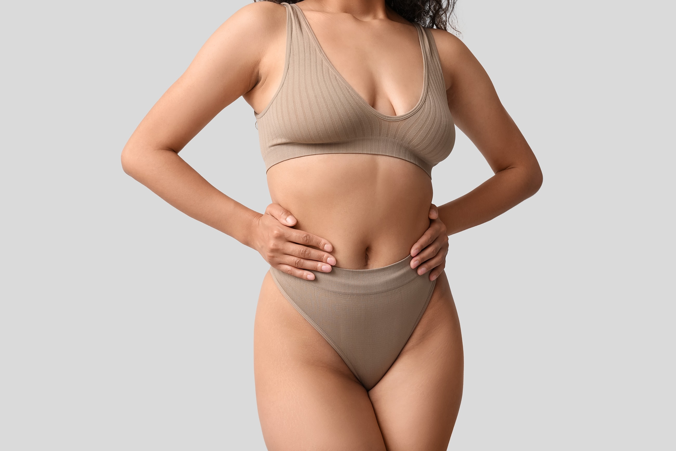 Model wearing beige ribbed activewear set.