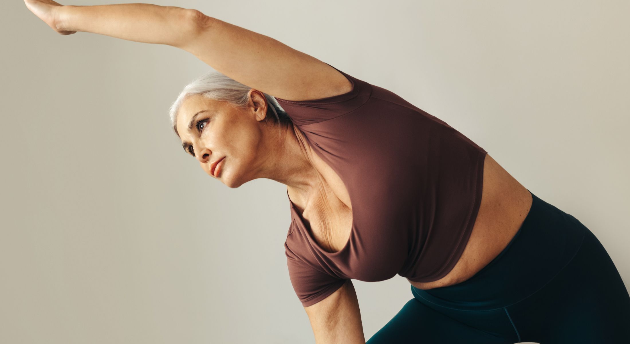 Senior woman practicing yoga poses gracefully.