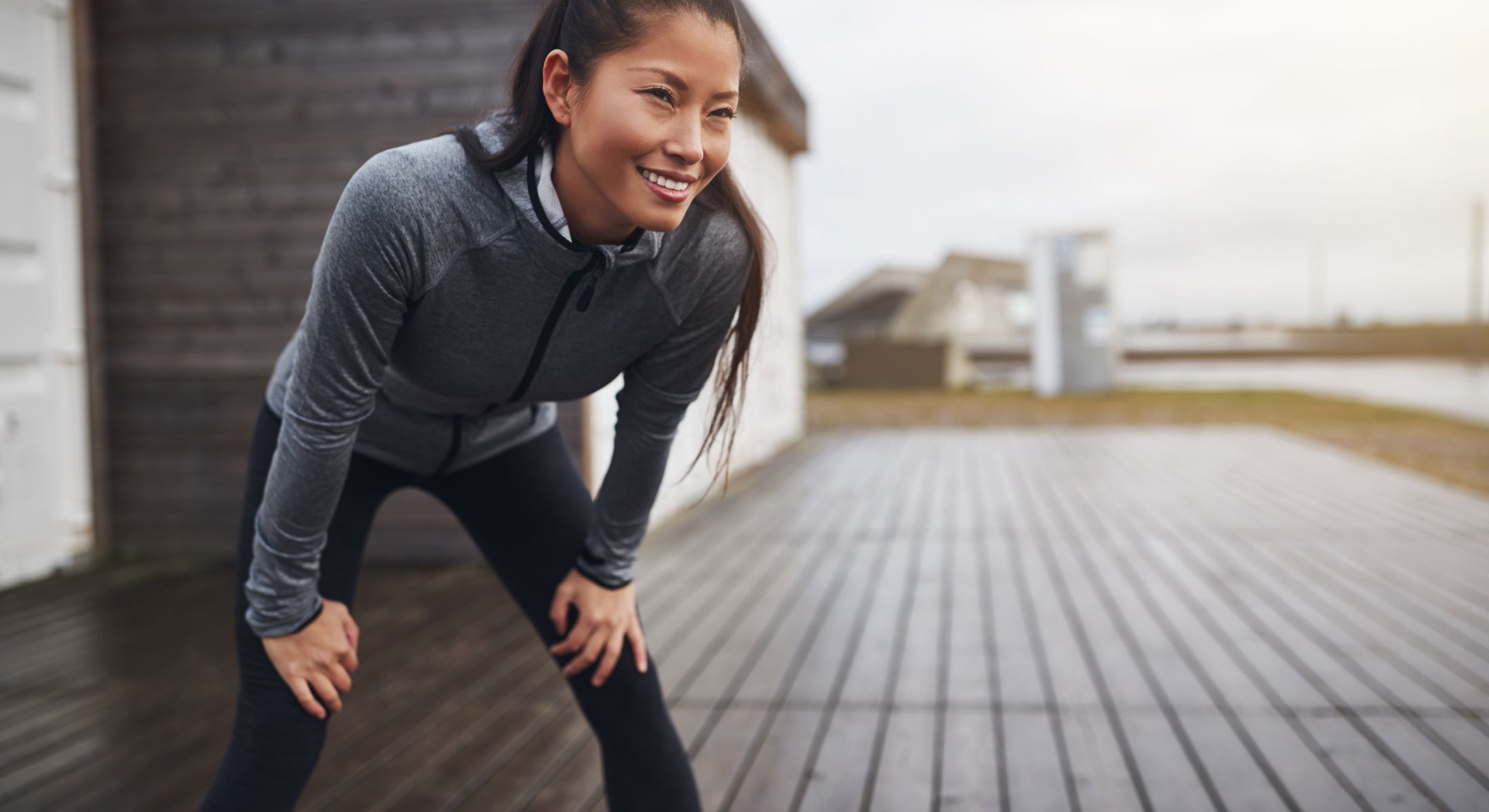 Smiling woman resting after a workout outdoors.